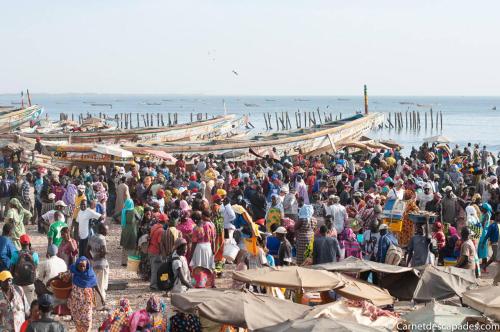 a large crowd of people standing on the beach at Keur Karim sarr in Mbour