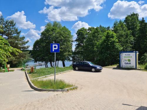 a car parked in a parking lot next to a sign at Apartament z garażem podziemnym - Augustowska in Olsztyn