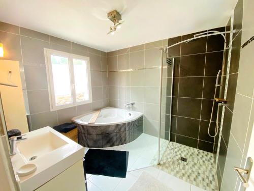 勒博塞VILLA 6 PERSONNES /PISCINE/CAMPAGNE/TERRAIN DE PETANQUE/15 km BANDOL的带浴缸、水槽和淋浴的浴室