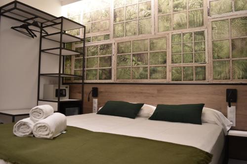 a bedroom with a large bed with towels on it at Casp Green House in Barcelona
