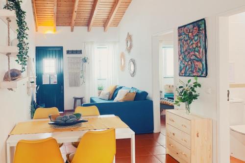 a living room with a table and a blue couch at Casa da Vila in Odeceixe