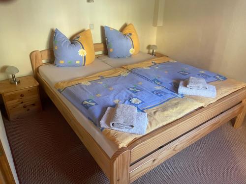 een bed met blauwe kussens en handdoeken erop bij Ferienhaus Schmidt in Rathmannsdorf