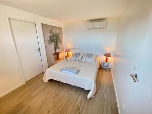 um quarto com uma cama num quarto com pisos em madeira em T2 standing 800m de la plage de St Clair em Le Lavandou