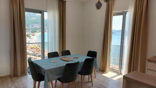 a dining room with a table and chairs with a view of the ocean at Hotel Kaligrosh in Sutomore
