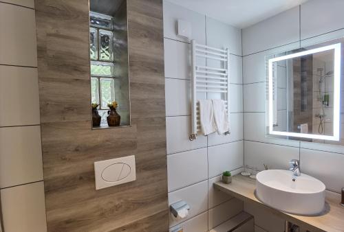 een badkamer met een wastafel en een spiegel bij Das Waldhaus in Forbach