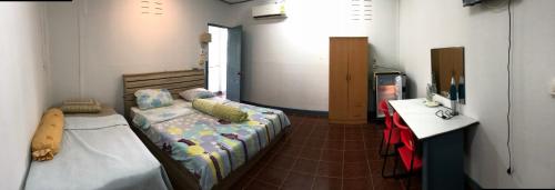 ein Schlafzimmer mit einem Bett und einem Schreibtisch. in der Unterkunft Baan Suan BBQ and Resort ชั้น2ห้อง9สองเตียง in Khon Kaen