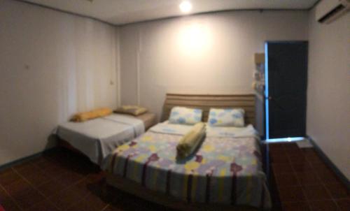 a bedroom with two beds in a room at Baan Suan BBQ and Resort ชั้น2ห้อง9สองเตียง in Khon Kaen