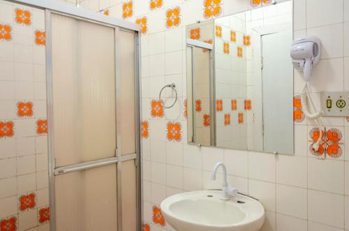 y baño con lavabo y ducha. en Beer Hostel Suites Privativas e Compartilhadas, en Ilhabela