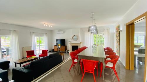 a living room with red chairs and a table at Fonte Santa by Check-in Portugal in Quarteira