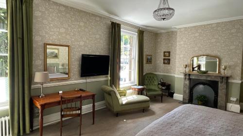 a bedroom with a bed and a tv and a fireplace at Ashdale Guesthouse in Matlock