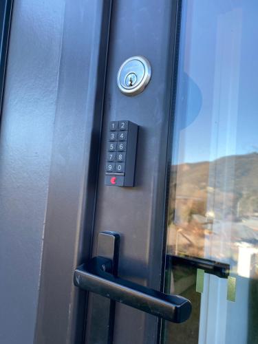a button on a door with a phone on it at Altura Apartment Bright in Bright