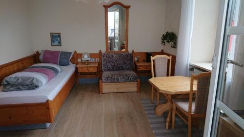 a bedroom with a bed and a table and a chair at Kloesterle in Bad Steben