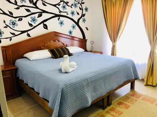 un dormitorio con cama con un animal de peluche en Delfin Dreams Cancún, en Cancún