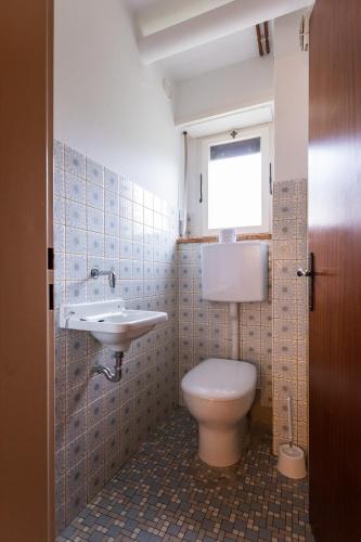 bagno con servizi igienici, lavandino e finestra di La Marmote Albergo Diffuso di Paluzza Naunina a Paluzza