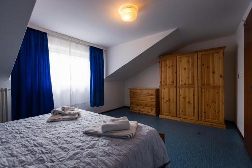 una camera da letto con un letto e asciugamani di La Marmote Albergo Diffuso di Paluzza Naunina a Paluzza