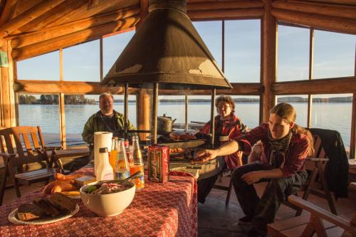 a group of people sitting at a table in a cabin at Herranniemi Guesthouse in Vuonislahti