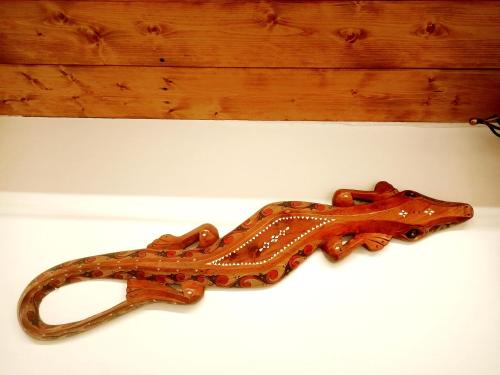 a wooden snake shaped object sitting on a table at La casa sul tetto, Room's & Glamping in Recanati