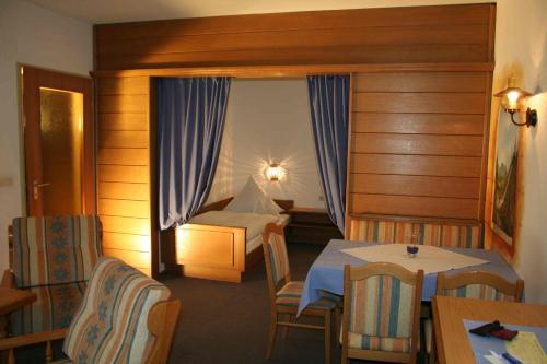 a hotel room with a bed and a table and chairs at Haus Feichtner in Reit im Winkl