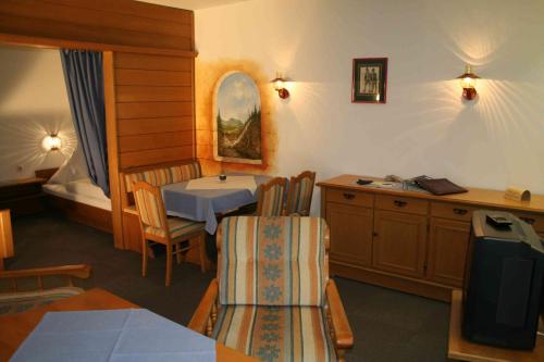 a room with a table and chairs and a bed at Haus Feichtner in Reit im Winkl