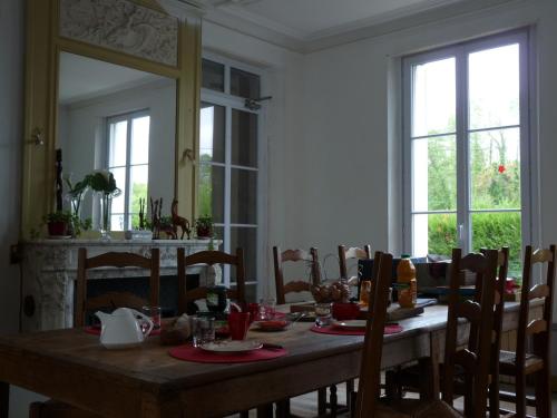 une salle à manger avec une table et un miroir dans l'établissement Le Betrot, à Estissac