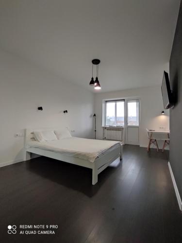 una camera da letto bianca con un letto e un tavolo di White Apartment a Poltava