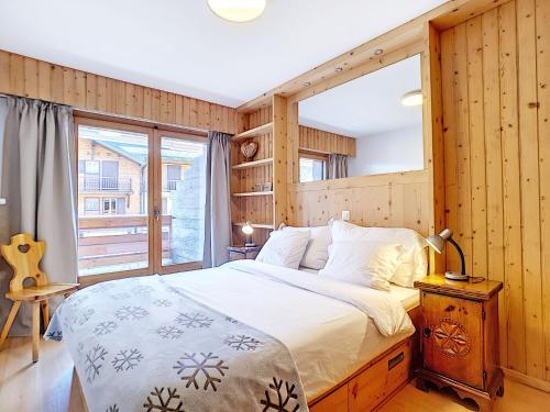 a bedroom with a large bed and a window at Square Poste 237 in Verbier