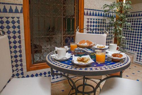 een tafel met eten en drinken erop bij Riad Dar Tamlil in Marrakesh