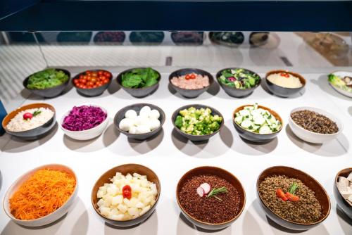 a display of bowls of different types of food at Suites Plaza Hotel & Wellness in Andorra la Vella