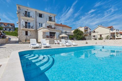 une villa avec une piscine en face d'une maison dans l'établissement Apartments Tamaris, à Tivat