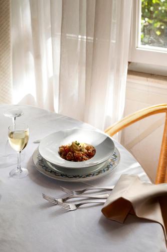 a plate of food on a table with a glass of wine at Hotel Mignon in Forte dei Marmi