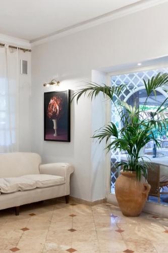 a living room with a couch and a plant at Hotel Mignon in Forte dei Marmi