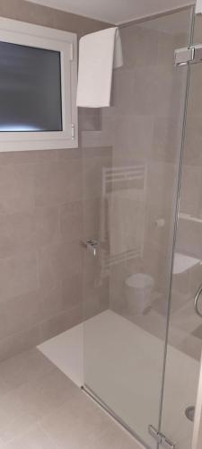 a shower with a glass door in a bathroom at Hotel Garbi in Calella de Palafrugell