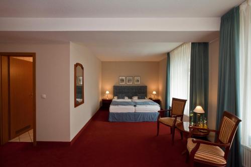 a hotel room with a bed and a table and chairs at Villa Knobelsdorff in Pasewalk