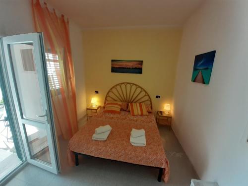 Schlafzimmer mit einem Bett und einer Glasschiebetür in der Unterkunft Casa Vacanza Fiorella in Torre dell'Orso
