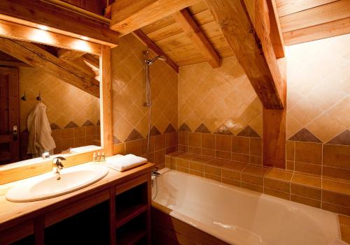a bathroom with a sink and a bath tub at Madame Vacances Chalet Marmotte in LʼHuez