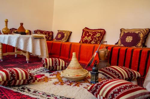 uma sala de estar com dois sofás vermelhos e almofadas em Auberge oued dades em Boumalne