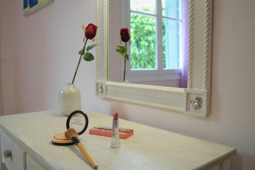a vanity with a mirror and a magnifying glass and a flower vase at Dolce Casa: Athenian Residence with private Garden in Athens