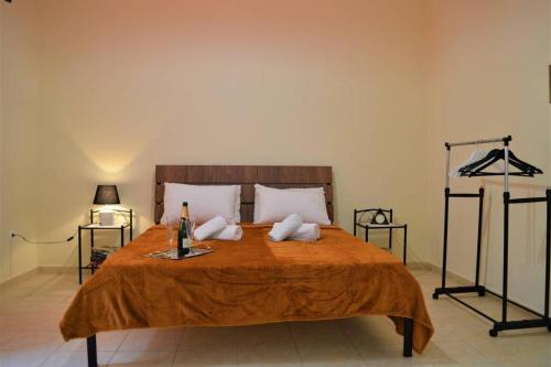 a bedroom with a large bed with a orange blanket at Dolce Casa: Athenian Residence with private Garden in Athens