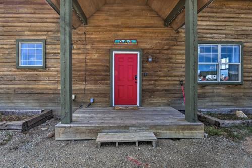 a red door on the front of a wooden building at 503 Mountain Loft with Views 1 Mi to Dwtn Fairplay! in Fairplay