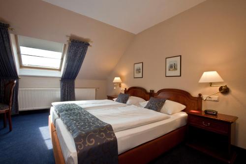 a bedroom with a large bed with a window at Villa Knobelsdorff in Pasewalk