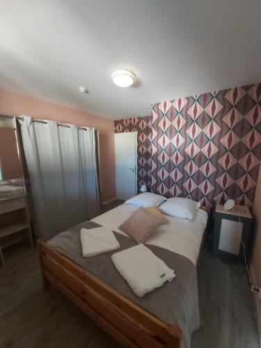 une chambre avec un grand lit avec des oreillers blancs dans l'établissement Le Petit Clos, à Commes