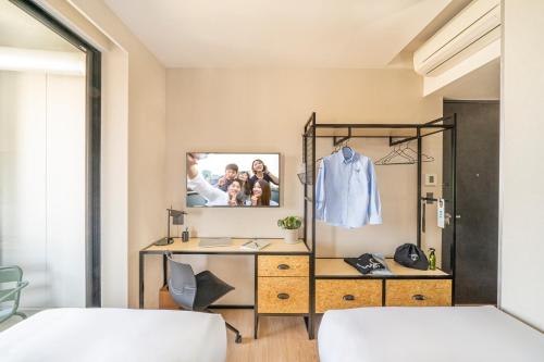 a bedroom with a desk and a dresser with a mirror at lyf Tenjin Fukuoka in Fukuoka