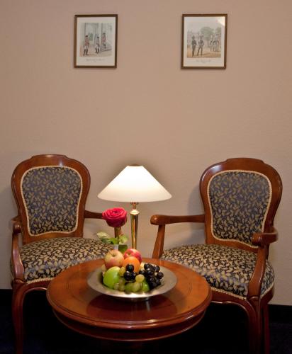 two chairs and a table with a bowl of fruit at Villa Knobelsdorff in Pasewalk