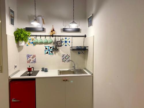 cocina con fregadero y armario rojo en Il Terzo Cardine, en Nápoles