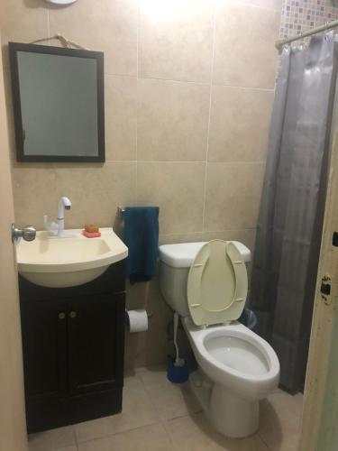 a bathroom with a toilet and a sink and a mirror at 777 LENDERMAN HoSTaL 777 in Cancún