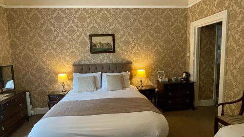 a bedroom with a large bed with two night stands and two lamps at Ashdale Guesthouse in Matlock