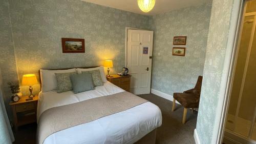 a bedroom with a bed and a desk and a chair at Ashdale Guesthouse in Matlock