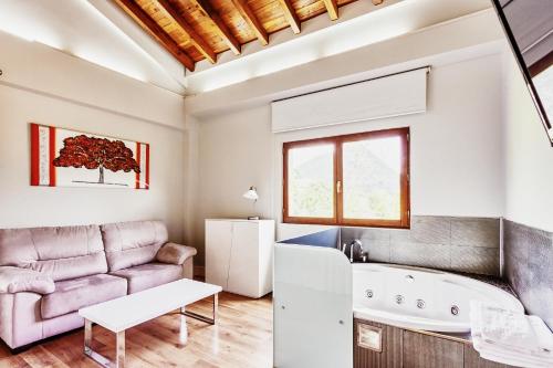 uma sala de estar com um sofá e uma banheira em Villa Arce Hotel em Puente Viesgo