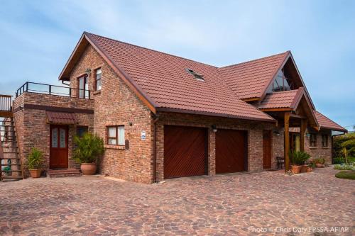 a brick house with a garage and a roof at Paradise Found in Knysna