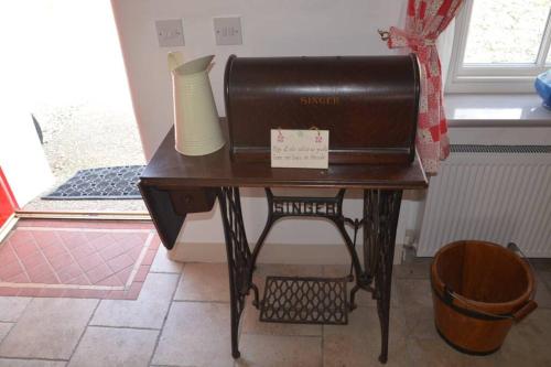 a small table with a vase on top of it at Cecil's Cottage, Ballynary, Buncrana by Wild Atlantic Wanderer in Buncrana